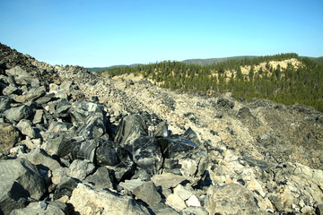 Large chunks of black obsidian glass exposed