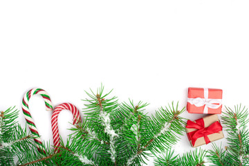 Christmas Frame of Fir tree branch with candy canes and snow isolated on white background with copy space for your text