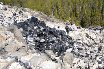 Large chunks of black obsidian glass exposed