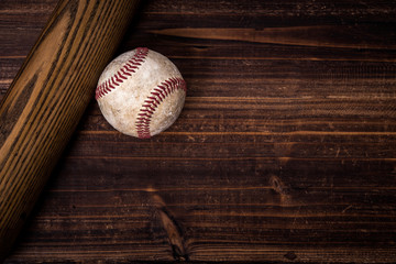A group of vintage baseball equipment, bat, baseball on wooden background