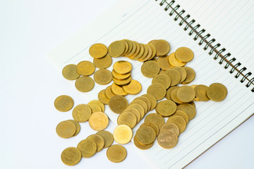 Step of coins stack on notebook paper with copy space for add text, financial and business planning concept.