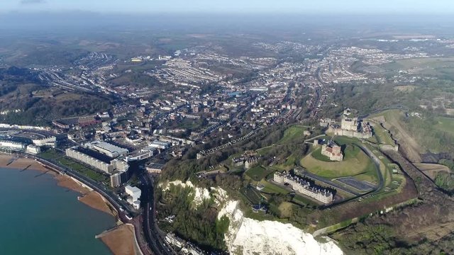 Aerial moving towards Dover is major ferry port in Kent South East England the town is the administrative centre of the district also showing a bit of the white cliffs and the famous castle on right