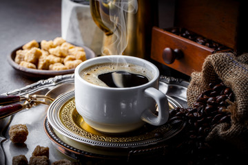 Black coffee in a cup on old background