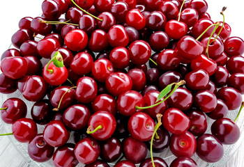 glass plate of fresh cherry berries close-up on white background top view
