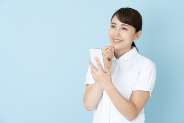 portrait of young asian nurse on blue background