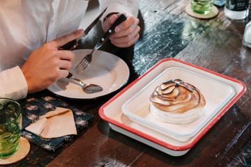 Fototapeta na wymiar Asian man Eat Fine dining dessert, burnt ice cream in white vintage plate over wooden table
