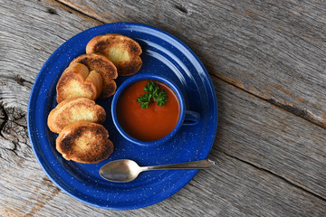 High angle shot of a mug of fresh homemade tomato soup with garlic toast
