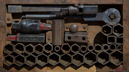 Isolated, close up overhead perspective of old sunlit socket set in a flat wooden toolbox