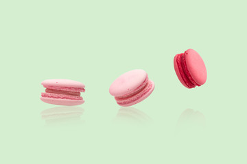 Many pink macaroons on the green background
