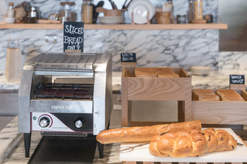 International buffet with assorted bread and toast line and toaster on table in breakfast buffet at...