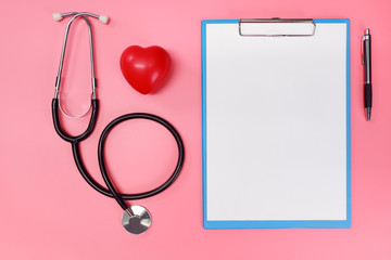 stethoscope with red heart symbol and blank paper on hospital desk