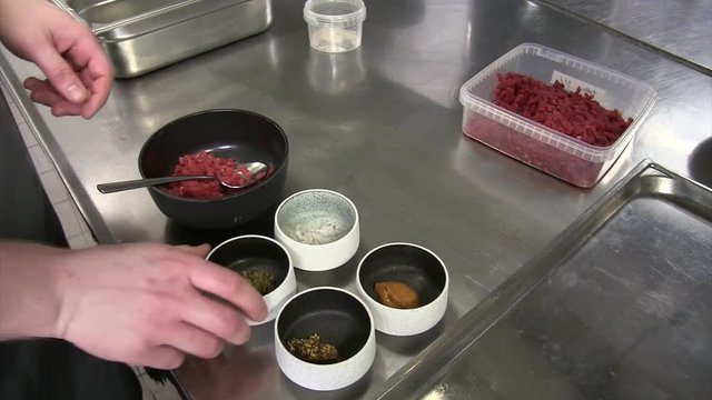 Chef putting the ingredients of tatar together to make the dish