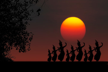 Silhouette of Thai classical dance and tree at sunset