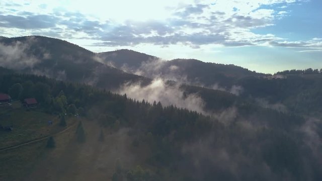 Gorgeous Overhead Aerial Drone Shot Through the Clouds Revealing a Campground in a Romanian Mountainside
