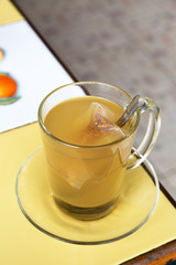Glass cup of hot ginger tea on table