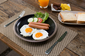 Fried eggs and sausage for breakfast on table