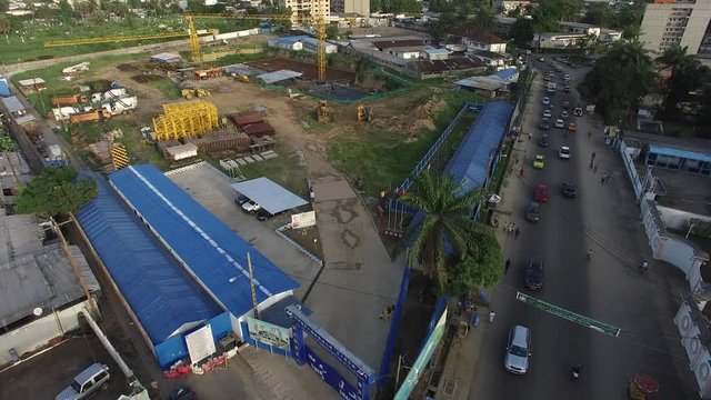 Douala construction park seen from above as the drone slowly lowers itself to expose more of the bustling streets below.