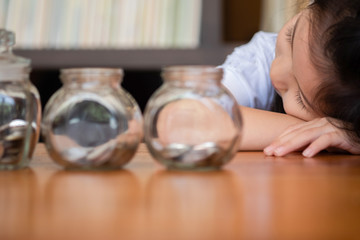 cute girl tired sleep on piggy bank,saving money concept