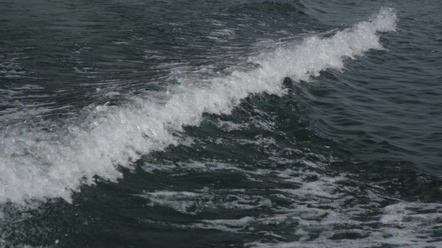 Slow motion footage of a boat's wake on a lake