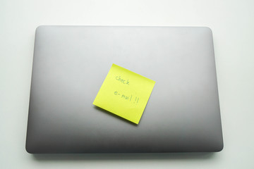 isolated postit note with text to check e-mail on laptop computer
