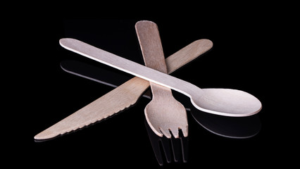 Environmentally friendly wooden cutlery on a black background