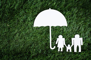 The familay paper cut put under the umbrella paper cut,on green grass ground floor,sign and symbol...