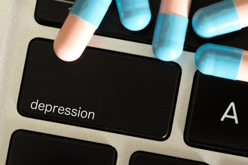 Tabletten, ein Computer und Taste Depression