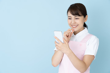 portrait of young asian nurse wearing apron on blue background