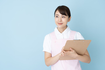 portrait of young asian nurse wearing apron on blue background