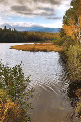 Fototapeta na wymiar Fall foliage along the shoreline of Stratton Brook Pond, Maine.