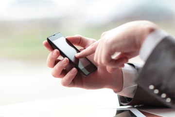 close up.businessman presses his finger on the screen of the sma