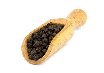 Black pepper on wooden scoop isolated on white background