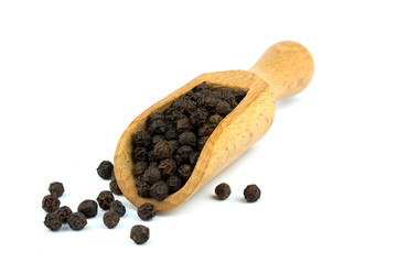 Black pepper on wooden scoop isolated on white background