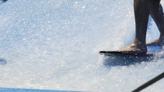 Man struggles to balance while surfing a wave machine