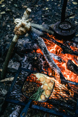 Cooking food on grill pan over campfire