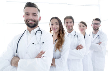 Group of happy successful doctors standing in a row in the hospital
