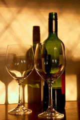 Sunlit wine bottle and glasses with shadows and reflections, lovely peaceful feeling