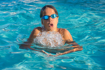 Fototapeta na wymiar Close up action shot of teenage boy, young athlete swimming breaststroke. Sport, recreation, lifestyle concept.