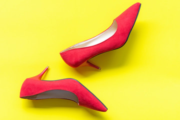 Fashion woman accessories set. Trendy fashion red shoes heels. Yellow pastel color background. Fashion Concept.