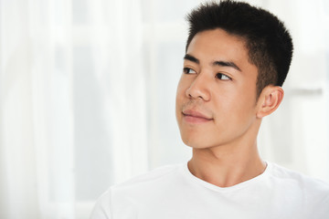 Head of handsome young mixed-race man smiling and looking away
