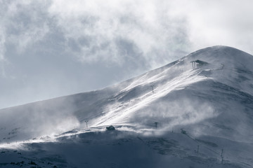 Strong wind gusts carry snow over Peak 8 near dusk in Breckenridge, CO