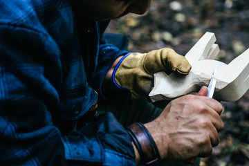 Man Holding Whittling Knife Carving Wooden Horse