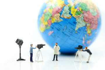 Miniature people : journalists , cameraman ,Videographer at work shooting with world using for concept of World Television Day.