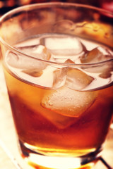 Cold alcoholic drink with ice on rustic vintage background