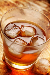 Cold alcoholic drink with ice on rustic vintage background