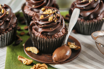 Sweet chocolate cupcakes with nuts on table