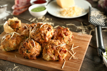 Wooden board with tasty sausage balls on table