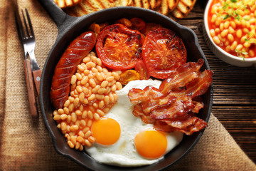 Traditional english breakfast food with eggs sausages bacon beans and toasts