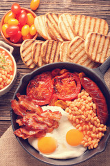 Traditional english breakfast food with eggs sausages bacon beans and toasts