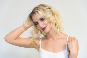 Beauty portrait of a beautiful blonde girl on a white background with perfect makeup.